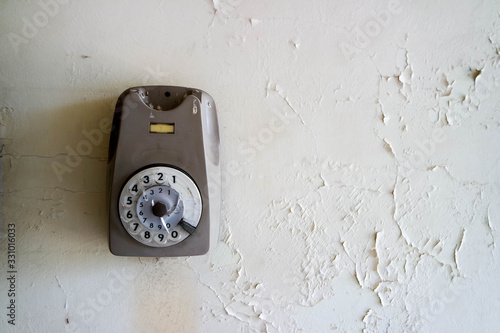 Vecchio telefono con rotella a muro rotto