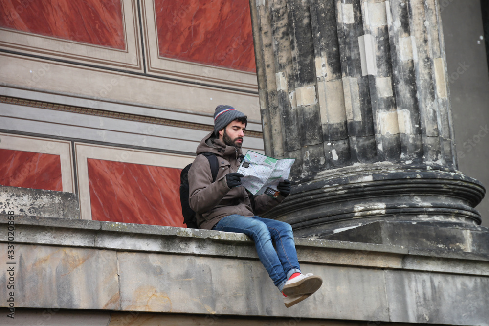 Seated Man looking at map of the most famous places in the city Seated Man looking at map of the most famous places in the city