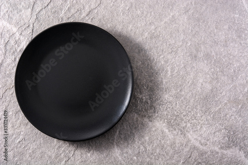 Empty black plate on gray background. Top view copy space