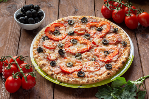 Pizza with olives, tomatoes, ham. Still-life. Assorted pizza