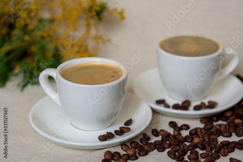 Two cups of fresh espresso with coffee beans. Sprinkled coffee beans. Morning coffee concept