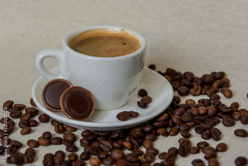 A cup of fresh espresso with chocolates. Coffee beans. Morning coffee concept A cup of fresh espresso with chocolates. Coffee beans. Morning coffee concept