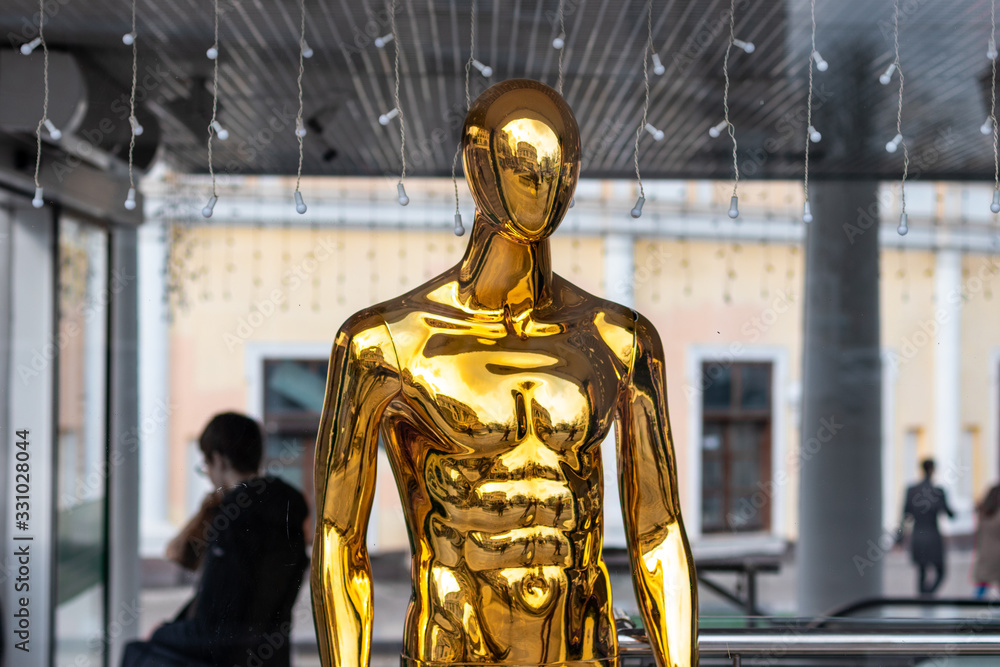 Gold fashion clothing store mannequin, shop window mannequin. Sale and discounts concept. Gold fashion clothing store mannequin, shop window mannequin. Sale and discounts concept.