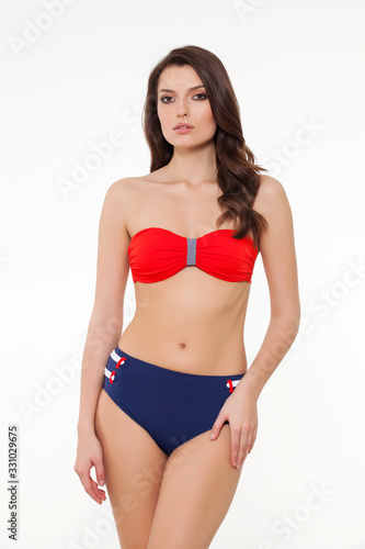 beautiful girl posing in stylish designed chic coral and navy blue bikini on white background.