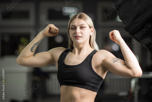 Fototapeta Naklejka Na Ścianę i Meble -  Portrait of a blond-haired girl with in the gym standing in a sports position.