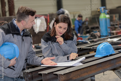 Valokuva Two factory workers are not sure about what the blueprint show