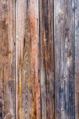 The old fence is made of unpainted planks with a worn surface.