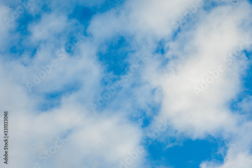 white fluffy clouds against a bright blue sky © David