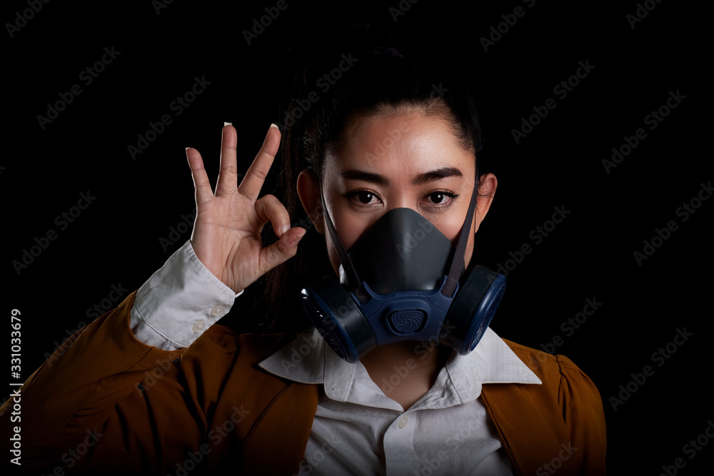 Asia woman putting on half mask replaceable particulate filter respirator  to protect from airborne respiratory diseases as the flu covid-19 coronavirus PM2.5 dust and smog, Women hand sign o.k
