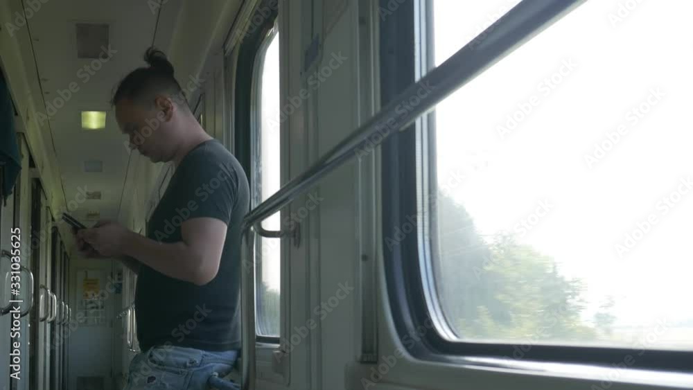 Male with smartphone travelling by train. Using technology in railway travel Male with smartphone travelling by train. Using technology in railway travel