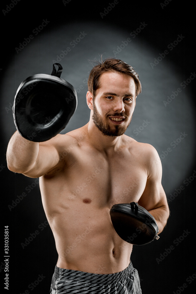 The boxer is a fighter, looking angrily at the camera. Young Caucasian male fitness model isolated on black background The boxer is a fighter, looking angrily at the camera. Young Caucasian male fitness model isolated on black background