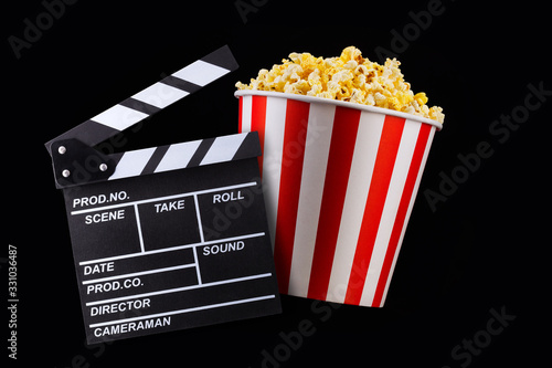 Paper striped bucket with popcorn isolated on black background