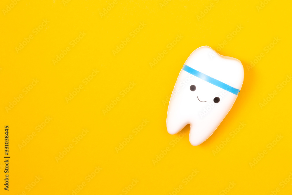 tooth model on a yellow background, happy tooth, smilling tooth, white healthy tooth, copy space, oral care concept tooth model on a yellow background, happy tooth, smilling tooth, white healthy tooth, copy space, oral care concept