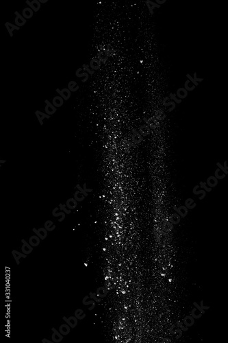 Started splash of white flour powder on black background.