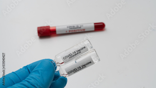 Doctor holds COVID 19 Coronavirus vaccine in his hand, infected blood sample in the sample tube, Vaccine and syringe injection It use for prevention, immunization and treatment from COVID-19