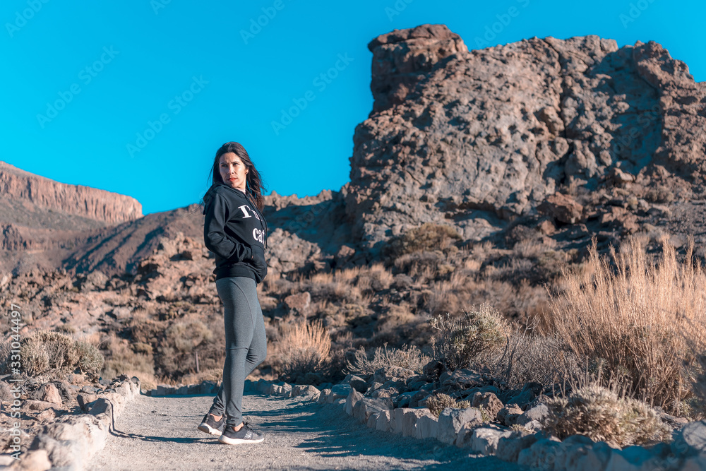 A young brunette walking on the Teide volcano. Tenerife