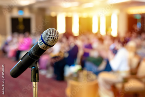 Close up of Microphone on stage, abstract blurred of speech in seminar room or speaking conference hall light, Event Background ,Shallow depth of field