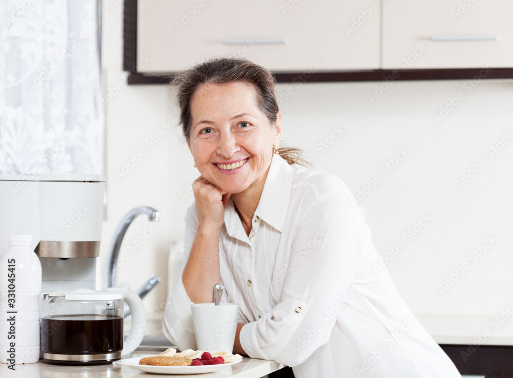 Portrait of nice elderly woman in kitchen Portrait of nice elderly woman in kitchen