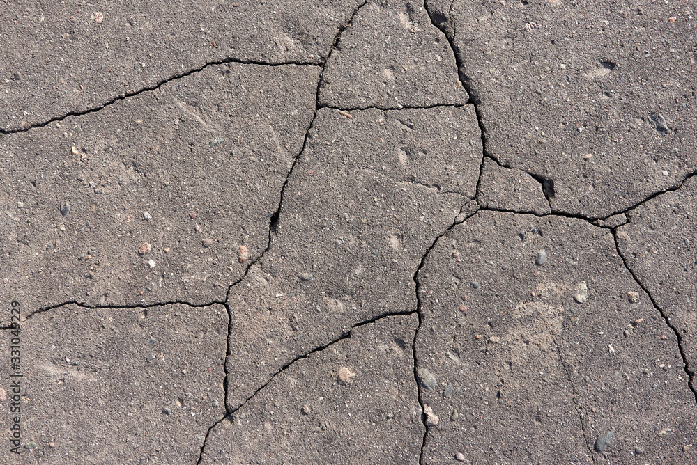 Obraz premium Cracks in grey concrete surface. Old destroyed asphalt with cracks. Asphalt in cracks texture.