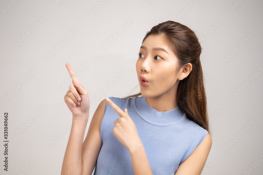 Thinking asian woman stand up isolated on white background.Asian female model smiling looking up.woman pointing fingers away. Thinking asian woman stand up isolated on white background.Asian female model smiling looking up.woman pointing fingers away.