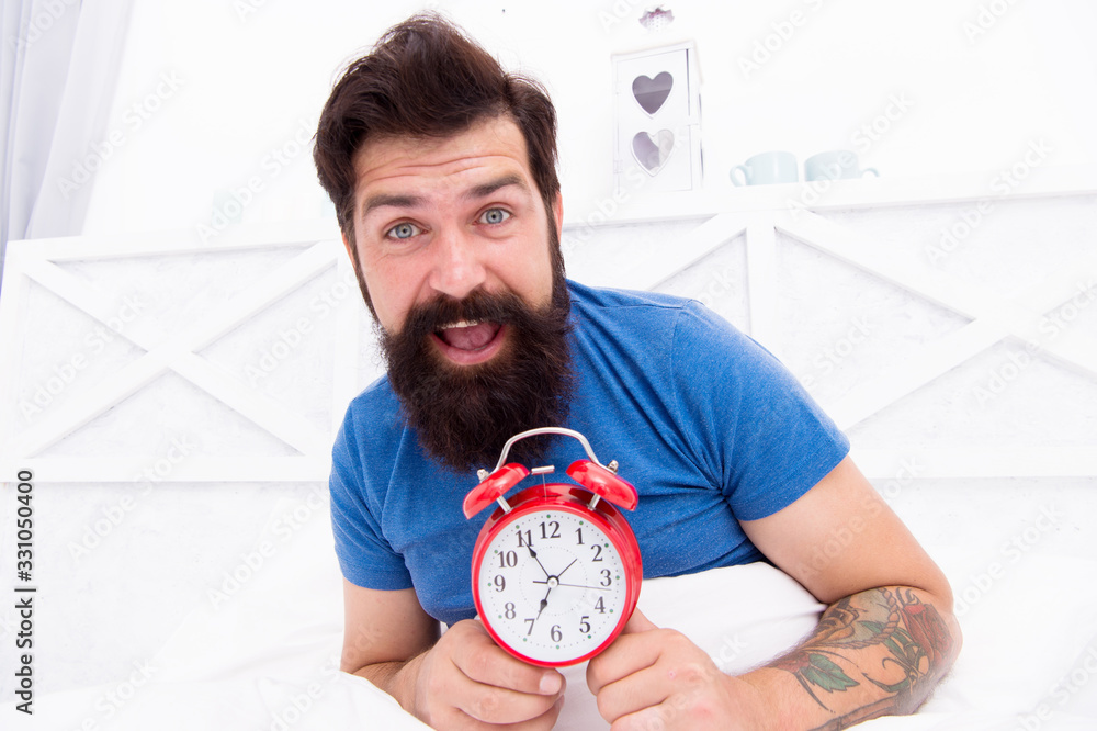 Healthy sleep concept. turn off alarm clock waking up at morning. getting ready in the morning. its almost seven. Man lying in bed with alarm clock in morning at 7am. good morning to you Healthy sleep concept. turn off alarm clock waking up at morning. getting ready in the morning. its almost seven. Man lying in bed with alarm clock in morning at 7am. good morning to you