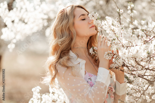 Pretty woman in blossom spring garden