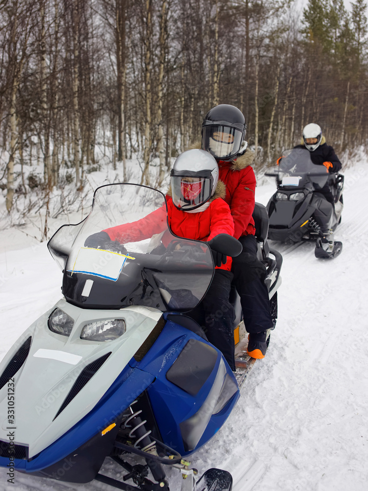 Family managing snow mobile in Ruka of Lapland Family managing snow mobile in Ruka of Lapland