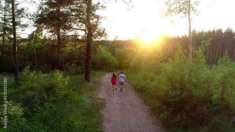 a couple in love walks through the woods and hugs. the view from the top a couple in love walks through the woods and hugs. the view from the top