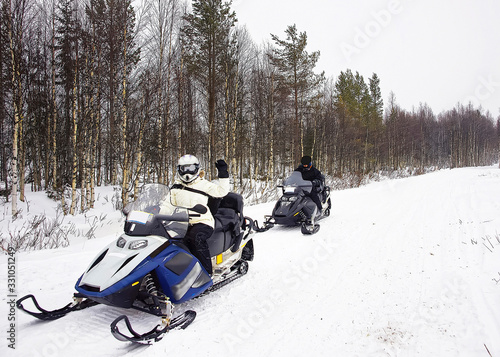 Canvas Print Woman and a Man driving snow mobile in Ruka of Lapland