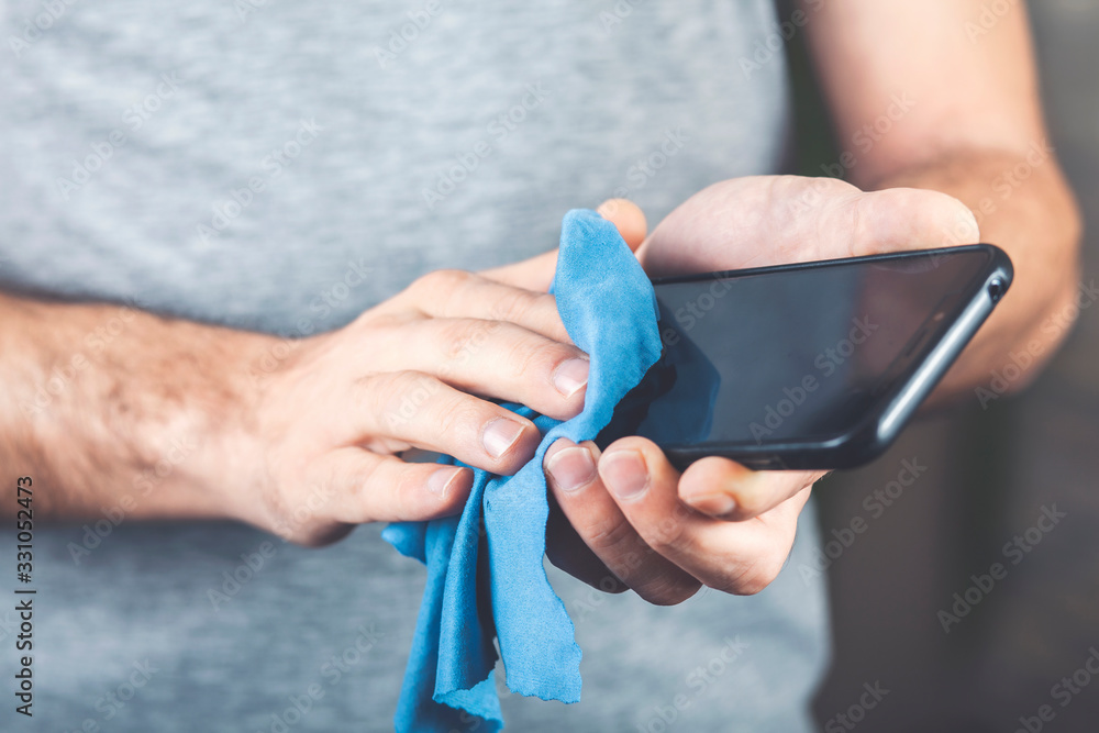 Man cleaning cell phone. Health prevention by virus