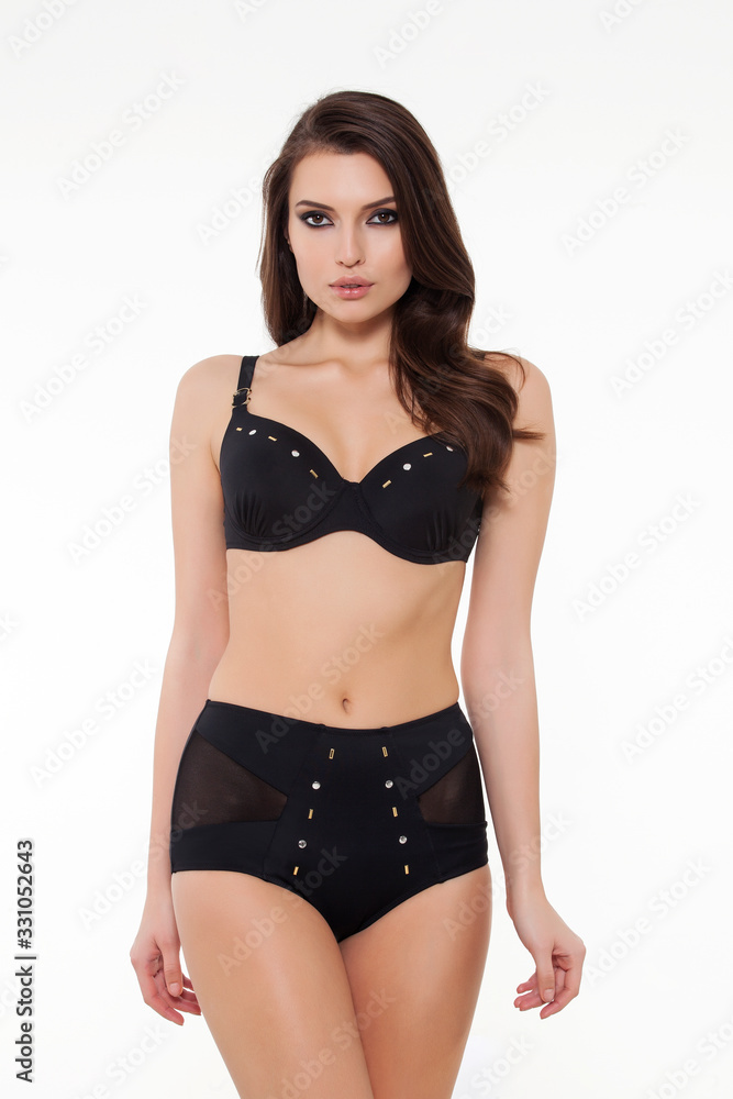beautiful girl posing in stylish detailed black bikini on white background. beautiful girl posing in stylish detailed black bikini on white background.