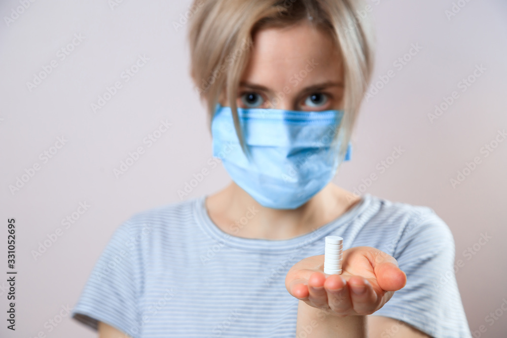 Girl with mask to protect her from Corona virus. Corona virus pandemic. Woman taking lot of white pills. close up Girl with mask to protect her from Corona virus. Corona virus pandemic. Woman taking lot of white pills. close up