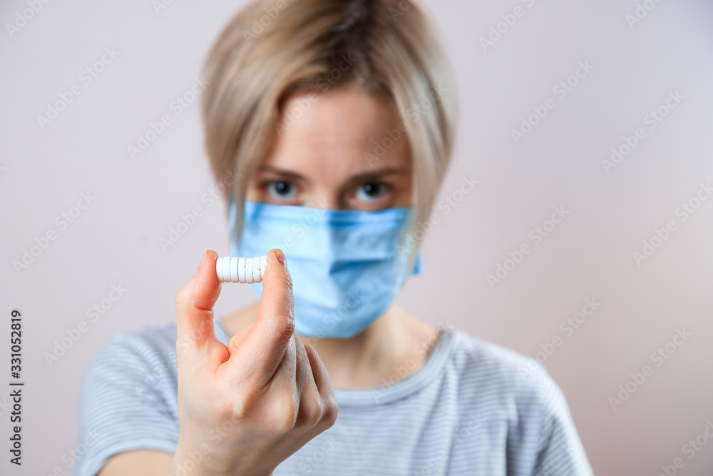 Girl with mask to protect her from Corona virus. Corona virus pandemic. Woman taking lot of white pills. close up Girl with mask to protect her from Corona virus. Corona virus pandemic. Woman taking lot of white pills. close up