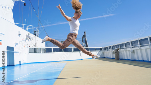 Rock sign performed by a curly curly girl. beautiful sporty girl on the deck of a cruise ship jumps Sign of the horns. Emotion fun joy on a sunny day. rest on a cruise ship. vacation © Artem