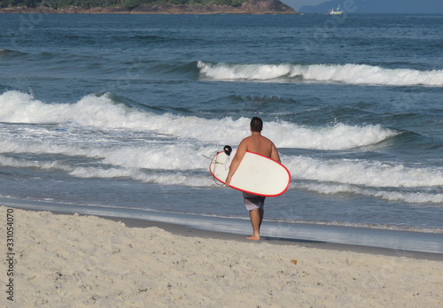Man with surfboard on a beach. Surfer on the beach