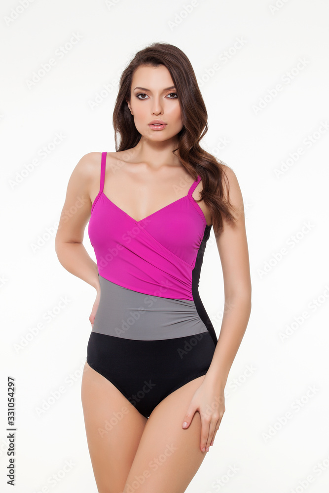 beautiful girl posing in stylish detailed black and purple tankini on white background. beautiful girl posing in stylish detailed black and purple tankini on white background.