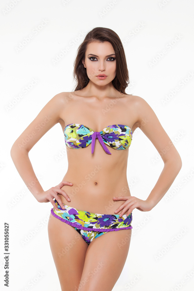 beautiful girl posing in stylish detailed colorful bikini on white background. beautiful girl posing in stylish detailed colorful bikini on white background.