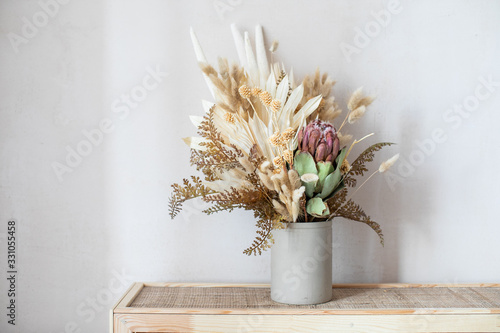 Minimalistic composition of dried flowers in cylindrical ceramic vase as home decoration. © Artem Bruk