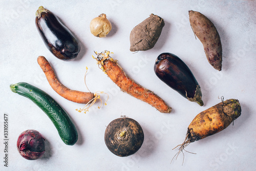 Ugly vegetables on grey background. Ugly food concept. Top view, flat lay.