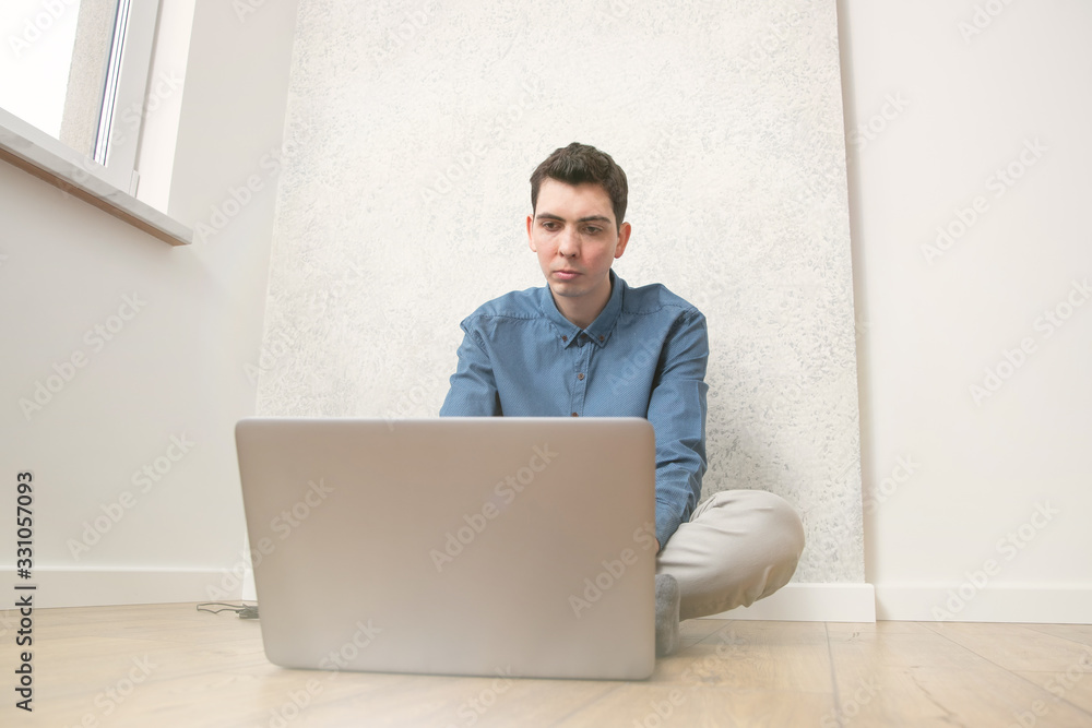 The guy works remotely from home at a computer The guy works remotely from home at a computer