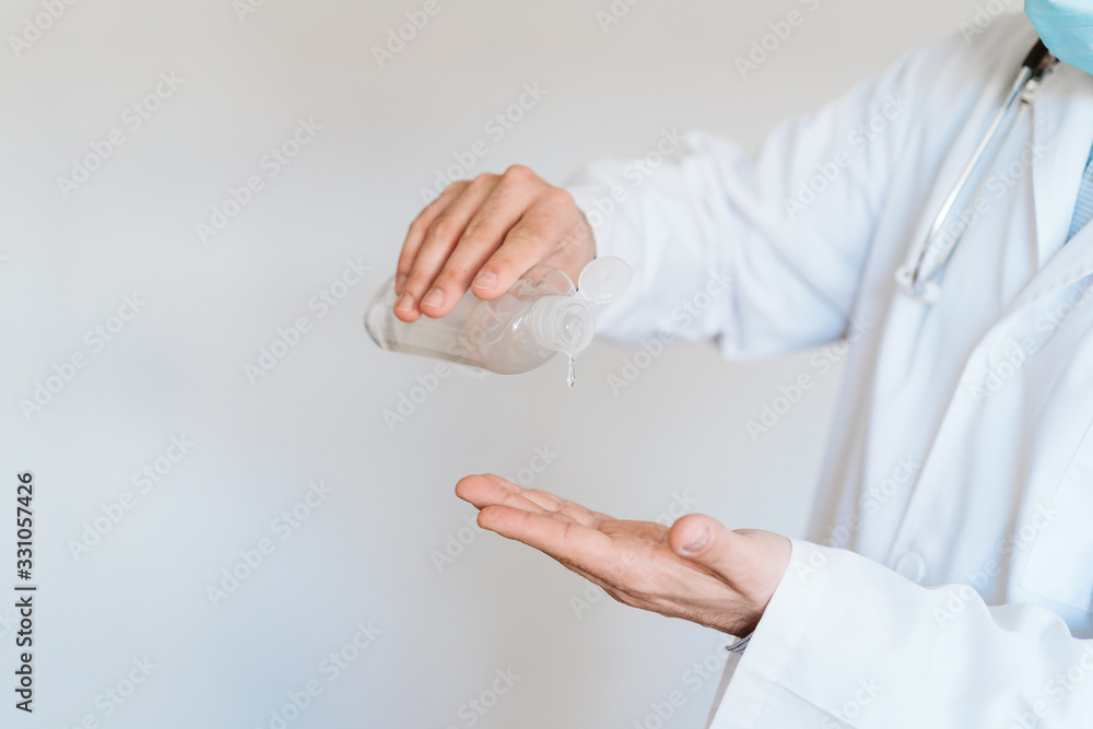 caucasian doctor wearing protective mask and gloves indoors. Using an alcohol gel or antibacterial disinfectant. Hygiene and corona virus concept caucasian doctor wearing protective mask and gloves indoors. Using an alcohol gel or antibacterial disinfectant. Hygiene and corona virus concept