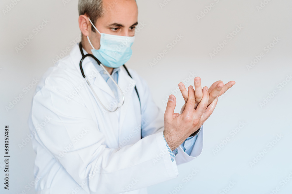 caucasian doctor wearing protective mask and gloves indoors. Using an alcohol gel or antibacterial disinfectant. Hygiene and corona virus concept caucasian doctor wearing protective mask and gloves indoors. Using an alcohol gel or antibacterial disinfectant. Hygiene and corona virus concept