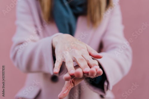 caucasian woman in the street using an alcohol gel or antibacterial disinfectant on hands. Hygiene and corona virus concept
