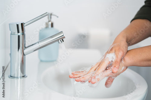 Obraz na płótnie Hygiene. Cleaning Hands. Washing hands with soap. Young woman washing hands with soap over sink in bathroom, closeup. Covid 19. Coronavirus. w salonie