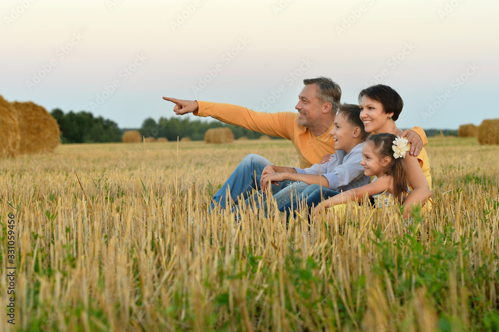 Happy family in summer field. man pointing with finger Happy family in summer field. man pointing with finger