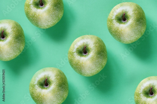 Pattern with fresh green aplles on green background, fruits for supermarket or advertisment photo