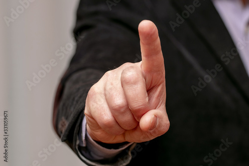 A man with his index finger raised up. Businessman pushes a button_
