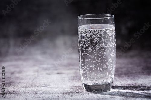 Glass of sparkling water on the grey background