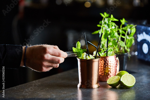 Cuba Libre, Rum and Cola drink with lime in copper mugs on a bar photo