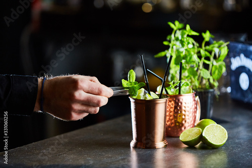 Картината върху платно Cuba Libre, Rum and Cola drink with lime in copper mugs on a bar